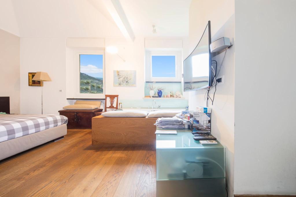 Image of a bedroom with bed, TV and modern furniture in Italian villa